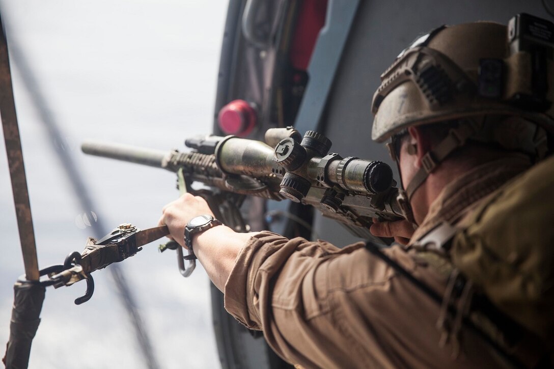 GULF OF ADEN (July 7, 2015) A U.S. Marine with the 15th Marine Expeditionary Unit’s Maritime Raid Force shoots at his target out of an MH-60S Sea Hawk from the “Blackjacks” of Helicopter Sea Combat Squadron 21. Marines with the MRF practiced aerial sniping from a helicopter to improve their accuracy shooting from the air. The 15th MEU is embarked on the Essex Amphibious Ready Group and deployed to maintain regional security in the U.S. 5th Fleet area of operations. (U.S. Marine Corps photo by Cpl. Anna Albrecht/Released)