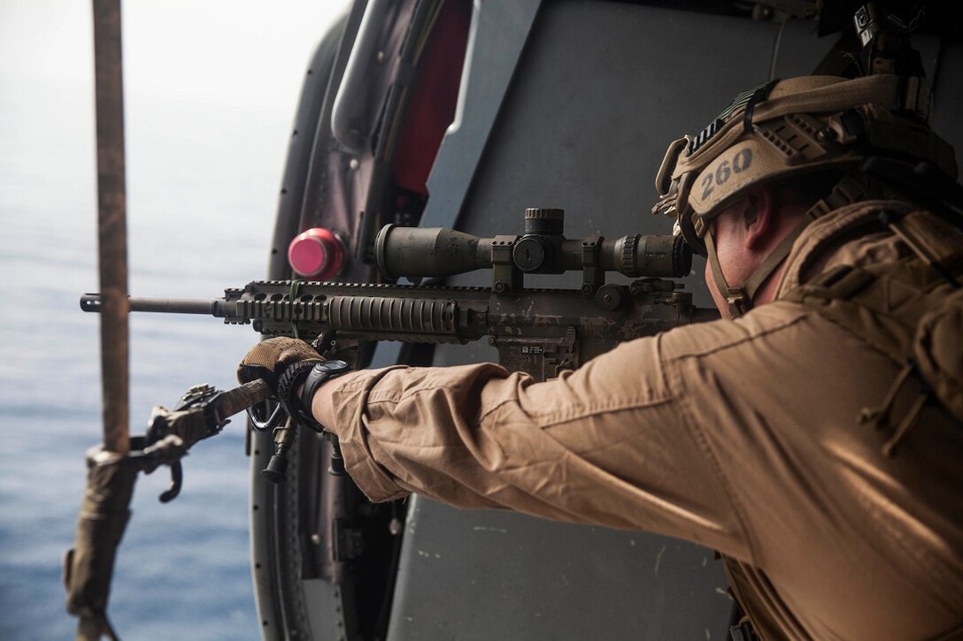 GULF OF ADEN (July 7, 2015) A U.S. Marine with the 15th Marine Expeditionary Unit’s Maritime Raid Force aims at his target out of an MH-60S Sea Hawk from the “Blackjacks” of Helicopter Sea Combat Squadron 21. Marines with the MRF practiced aerial sniping out of the helicopter to work on their accuracy shooting from the air. The 15th MEU is embarked on the Essex Amphibious Ready Group and deployed to maintain regional security in the U.S. 5th Fleet area of operations. (U.S. Marine Corps photo by Cpl. Anna Albrecht/Released)