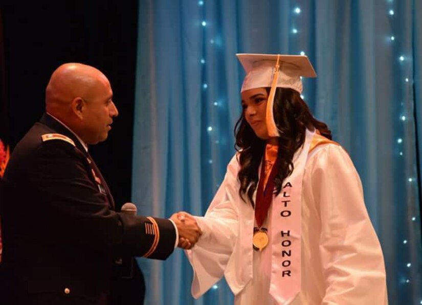 Assistant Chief of Staff Lt. Col. Arturo Calzadillas Jr. (left) congratulates Jomarly Cruz Galarza, 17, (right), daughter of Sgt. 1st Class Joel Cruz, assigned to the 1st Mission Support Command, U.S. Army Reserve-Puerto Rico, during her high school graduation ceremony held at Centro de Bellas Artes of Guaynabo, May 22.