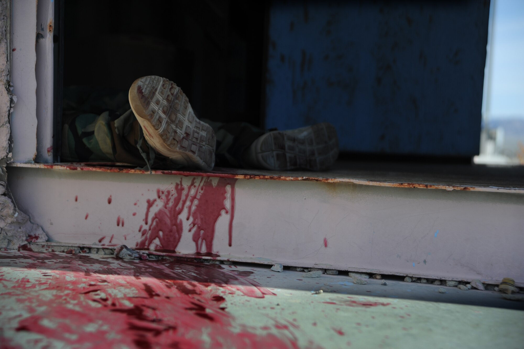 U.S. Army Specialist Dana Tamayo, Guam Army National Guard Medical Detachment member, lies in a doorway simulating a casualty during the Operation Joint Medic training exercise