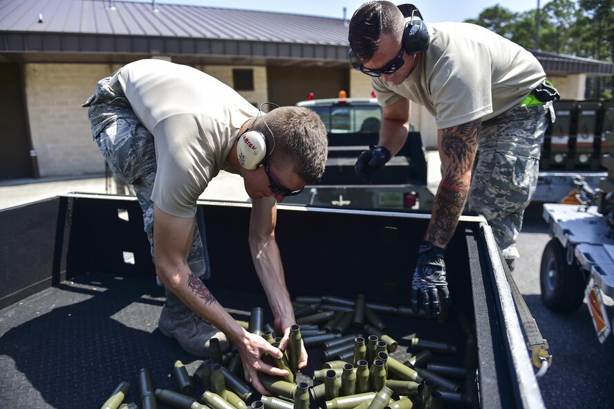 Airman 1st Class David Rehnert and Senior Airman Cody DeArk, 1st Special Operations Equipment Maintenance Squadron conventional maintenance crew chiefs, gather 25mm shells at Hurlburt Field, Fla., June 23, 2015. The shells are gathered for inspection then recycled. (U.S. Air Force photo/Senior Airman Jeff Parkinson)
