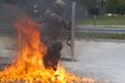 Spc. Michael Morales with the 1st Battalion, 252nd Armor Regiment’s Alpha Company, maneuvers his way through flames of a broken Molotov cocktail thrown by a member of the Portuguese army military police during fire phobia training June 16 in Hohenfels, Germany. This exercise is designed to help peacekeeping troops actively go through the steps of what to do when Molotov cocktails are encountered during crowd and riot control.