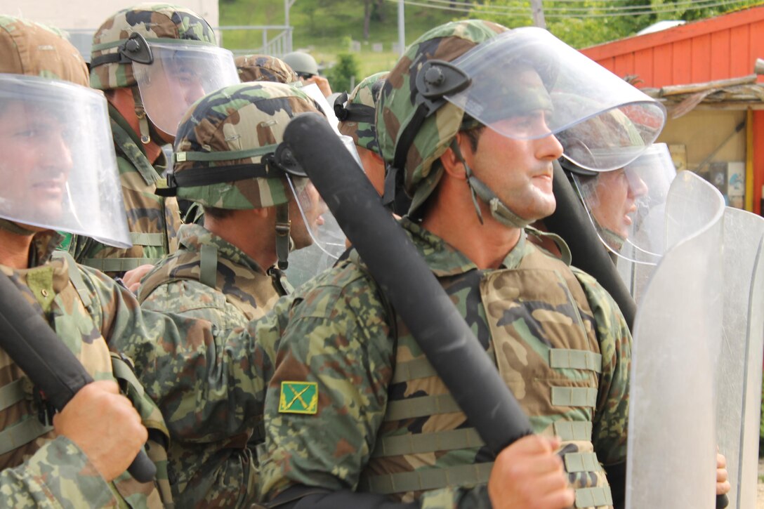 Troops with the Albanian Army take part in a crowd and riot control exercise at the Joint Multinational Readiness Training Center June 22 in Hohenfels, Germany. Crowd and riot control is preparatory training used by the JRMC for multinational forces taking part in security and peacekeeping missions. (U.S. Army Photo By Lt. Col. Gilbert Buentello)