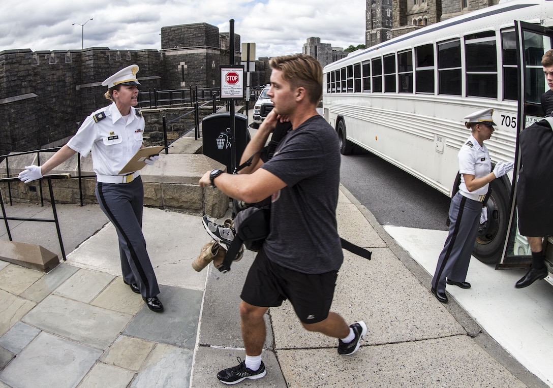 A future cadet reporting to the United States Military Academy at West Point on R-day steps off the bus and is ushered into Thayer Hall by a Cow, or cadet in her junior year, where he will be issued uniforms and processed for entrance into the Academy. Almost 1,300 future cadets reported on R-day at West Point which is typically held every year on the last Monday in June. (U.S Army photo by Sgt. 1st Class Brian Hamilton)