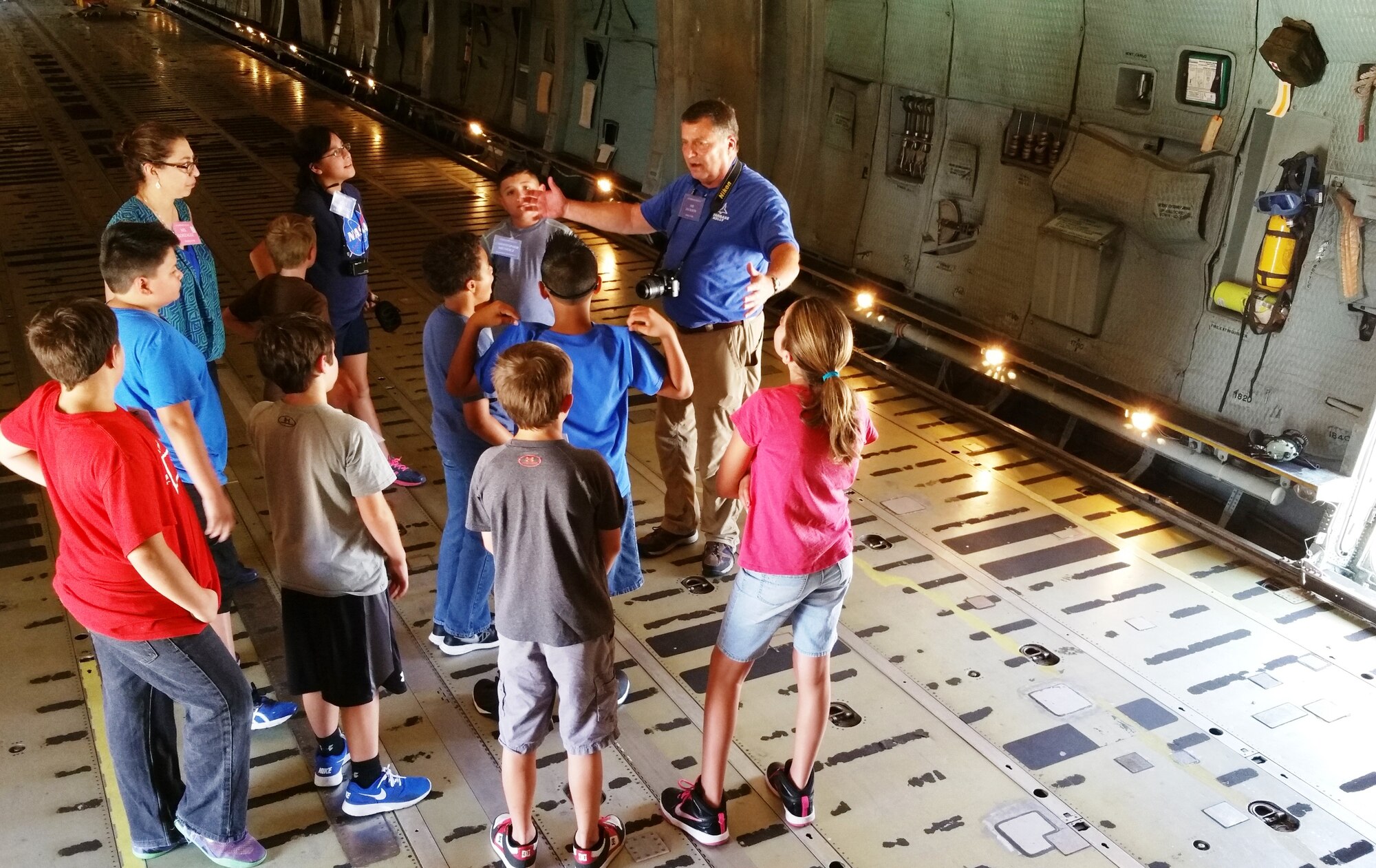 Ron Jackson (right), Starbase Kelly director, talks to a group of Starbase Kelly students about the capabilities of the C-5A Galaxy aircraft at Joint Base San Antonio-Lackland, Texas on July 13, 2015.  His program falls under the Department of Defense and is under the sponsorship of the 433rd Airlift Wing. The week long class has nearly 25 students enrolled. This week’s class has nearly 25 students enrolled. The students will do science experiments, try a flight simulation program, then build and launch a rocket to demonstrate their lessons learned. (U.S. Air Force photo/Tech. Sgt. Carlos J. Trevino)