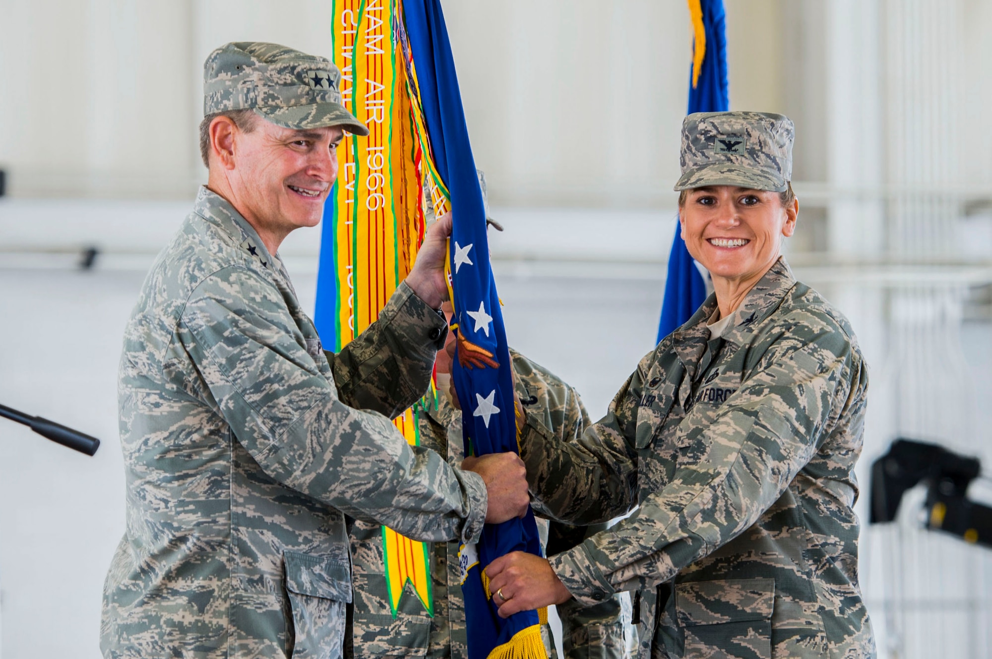 U.S. Air Force Maj. Gen. H.D. Polumbo, 9th Air Force commander, passes the guidon to Col. Caroline Miller, 633rd Air Base Wing incoming commander, during a change of command ceremony at Langley Air Force Base, Virginia, July 13, 2015. Miller assumed command of more than 9,000 military and civilian personnel across Joint Base Langley-Eustis. (U.S. Air Force photo by Senior Airman Kayla Newman/Released)