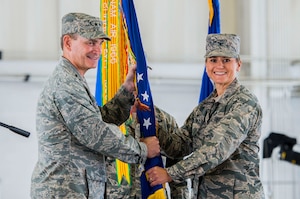 U.S. Air Force Maj. Gen. H.D. Polumbo, 9th Air Force commander, passes the guidon to Col. Caroline Miller, 633rd Air Base Wing incoming commander, during a change of command ceremony at Langley Air Force Base, Virginia, July 13, 2015. Miller assumed command of more than 9,000 military and civilian personnel across Joint Base Langley-Eustis. (U.S. Air Force photo by Senior Airman Kayla Newman/Released)