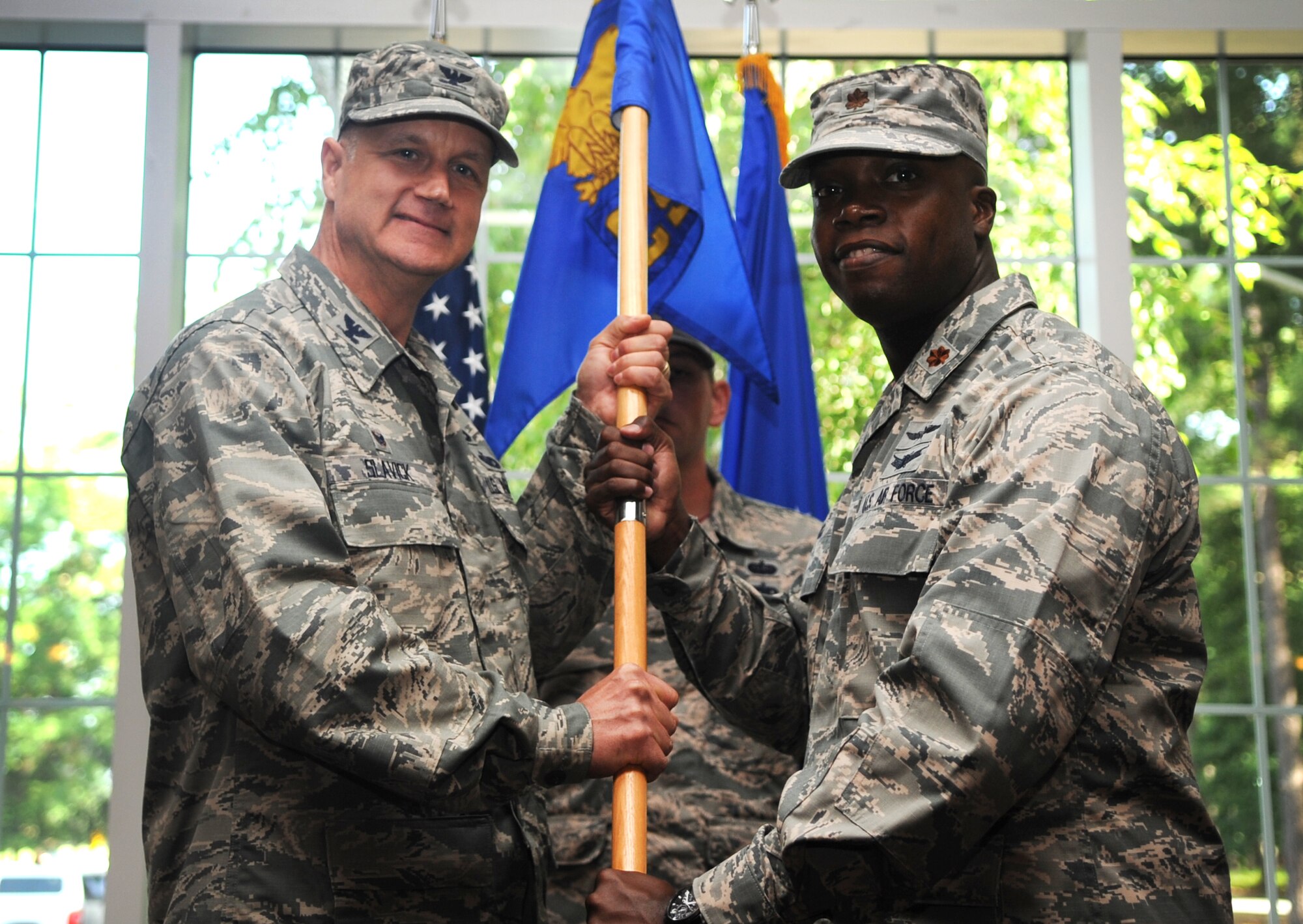 Maj. Gideon Hall, incoming 4th Communications Squadron commander, accepts the guidon from Col. Joe Slavick, 4th Mission Support Group commander, during a change of command ceremony, July 10, 2015, at Seymour Johnson Air Force Base, North Carolina. The 4th CS is made up of more than 80 personnel who support command, control, communications and computers systems, and maintain and operate the base’s $17 million network infrastructure. (U.S. Air Force photo/Senior Airman Ashley J. Thum)