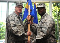 Maj. Gideon Hall, incoming 4th Communications Squadron commander, accepts the guidon from Col. Joe Slavick, 4th Mission Support Group commander, during a change of command ceremony, July 10, 2015, at Seymour Johnson Air Force Base, North Carolina. The 4th CS is made up of more than 80 personnel who support command, control, communications and computers systems, and maintain and operate the base’s $17 million network infrastructure. (U.S. Air Force photo/Senior Airman Ashley J. Thum)