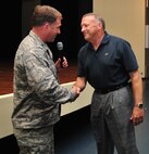 Col. Mark Slocum, 4th Fighter Wing commander, coins retired Gen. Gary North during a Leadership Lecture Series event, July 9, 2015, at Seymour Johnson Air Force Base, North Carolina. North retired from the Air Force after more than 35 years of service. (U.S. Air Force photo/Senior Airman John Nieves Camacho)