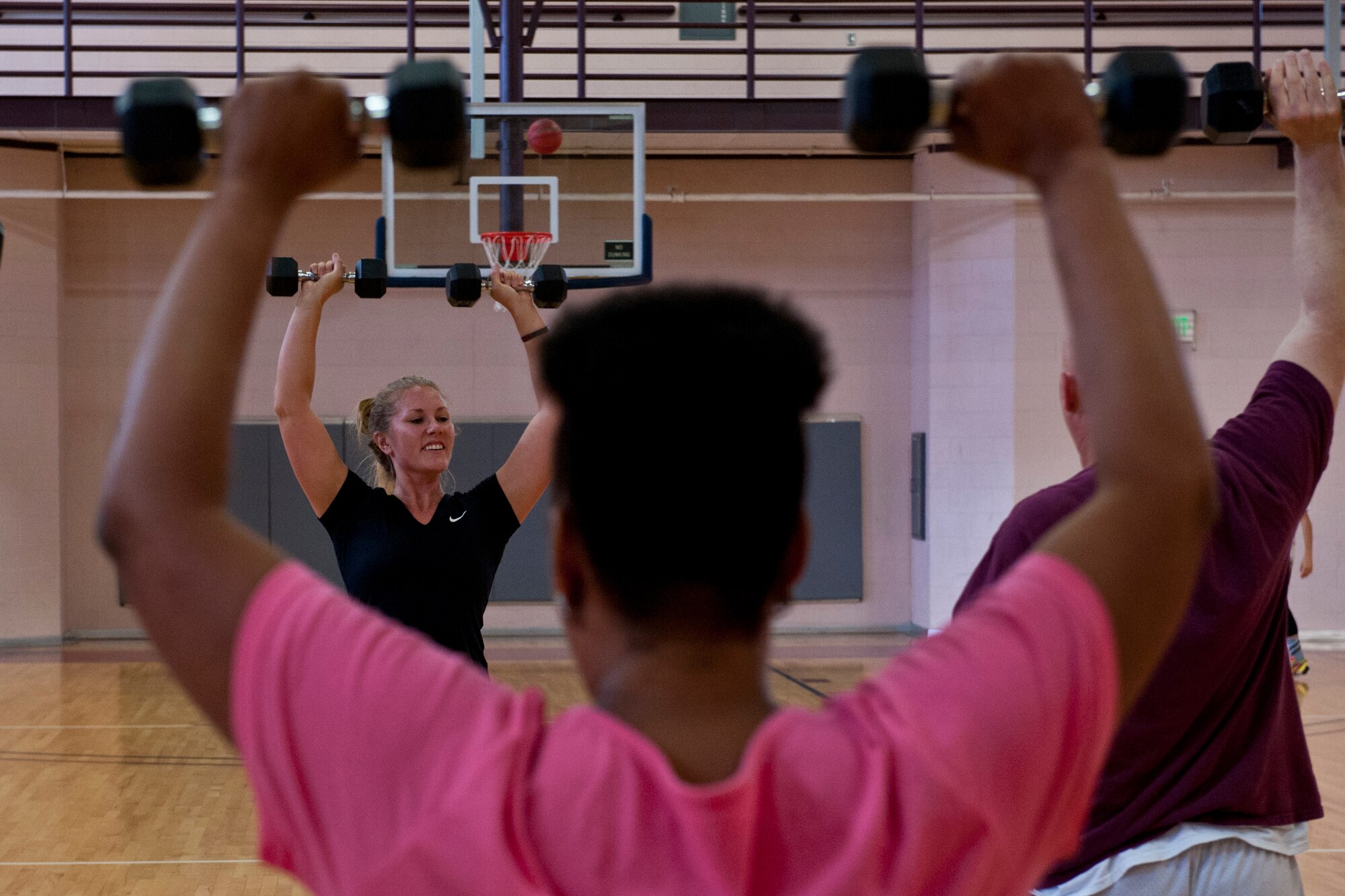 PETERSON AIR FORCE BASE, Colo. – Sarah Morris, fitness instructor, teaches participants in the new The Compound class how to properly do exercises and leads them by example at the Peterson Air Force Base Fitness Center, July 8, 2015. By incorporating cardio with weight lifting intervals, the new course burns calories while building muscles for a total body workout. The class began July 1 and will continue every Wednesday from 12:05–1 p.m. (U.S Air Force photo by Airman 1st Class Rose Gudex)