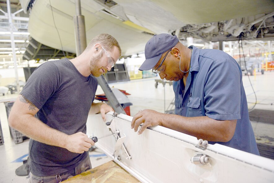 From left, Eric Acree, 569th Aircraft Maintenance Squadron aircraft mechanic, and Mike Webb, hydraulic work lead, repair a C-5 Galaxy bulkhead for an aircraft undergoing programmed depot maintenance at Robins. C-5 aircraft provide the Air Force with a heavy intercontinental-range strategic airlift capability. (U.S. Air Force photo by Tommie Horton)