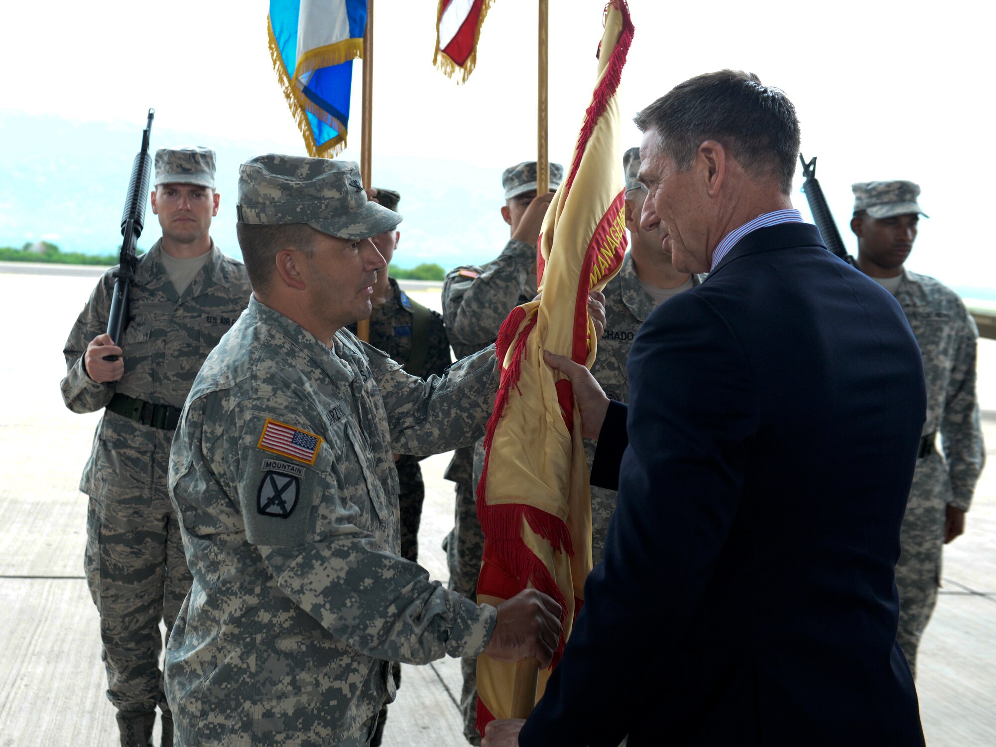 Col. Dan Barzyk, Army Support Activity incoming commander, receives the guidon from Mr. Thomas Schoenbeck, U.S. Army Installation Management Command regional director, during the Army Support Activity change of command July 9, 2015, at Soto Cano Air Base, Honduras. The change of command signified the passing of responsibilities from the previous commander, Col. Rollin Miller, to Barzyk. (U.S. Air Force photo by Staff Sgt. Jessica Condit)