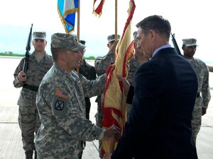 Col. Dan Barzyk, Army Support Activity incoming commander, receives the guidon from Mr. Thomas Schoenbeck, U.S. Army Installation Management Command regional director, during the Army Support Activity change of command July 9, 2015, at Soto Cano Air Base, Honduras. The change of command signified the passing of responsibilities from the previous commander, Col. Rollin Miller, to Barzyk. (U.S. Air Force photo by Staff Sgt. Jessica Condit)