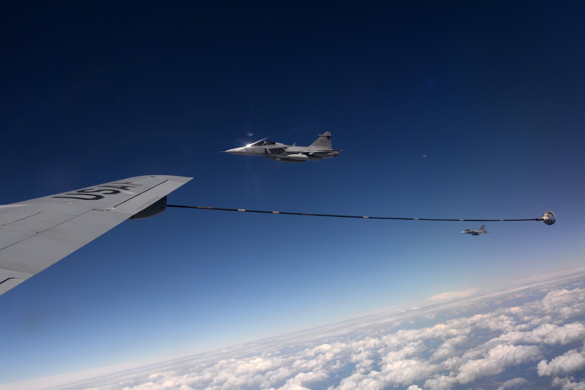 Swedish and Hungarian air force JAS-39 Gripens fly next to a U.S. Air Force KC-135 Stratotanker June 25, 2015, during air refueling familiarization training over Hungary. Hungarian, U.S. and Swedish air force personnel met for a two-week familiarization period enabling the Hungarian JAS-39 Gripen pilots to successfully perform air refueling for the first time. (U.S. Air Force photo by Senior Airman Kate Thornton/Released)