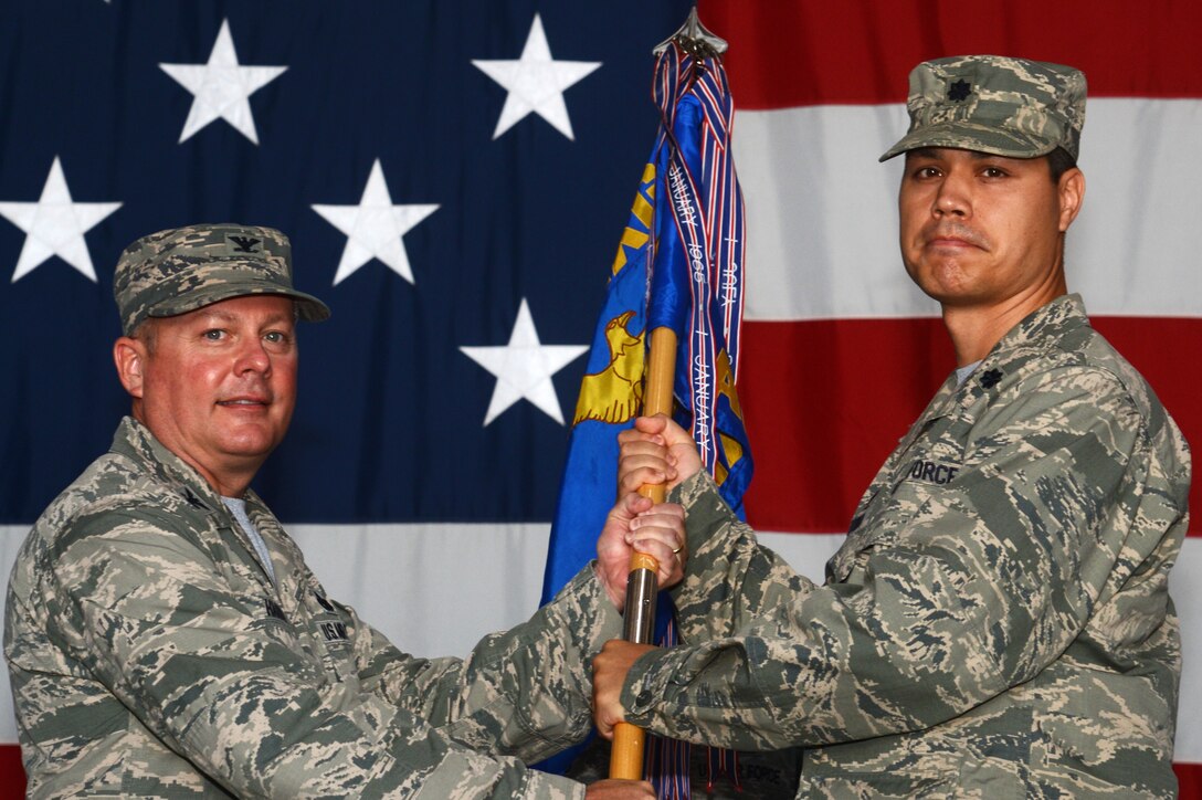 U.S. Air Force Lt. Col. Paul Tower, incoming 20th Aircraft Maintenance Squadron commander, receives the guidon from Col. Bryan Harris, 20th Maintenance Group commander, during a change of command ceremony at Shaw Air Force Base, S.C., July 10, 2015. By accepting the guidon, Tower accepted command of the squadron and the Airmen assigned to it. (U.S. Air Force photo by Senior Airman Jonathan Bass/Released)