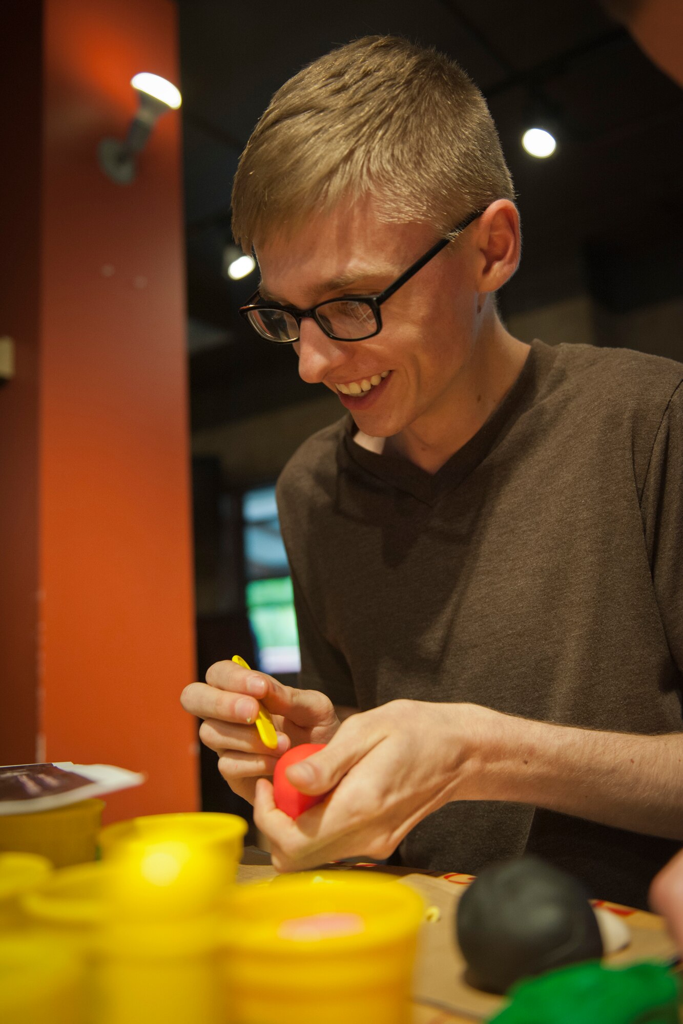 PETERSON AIR FORCE BASE, Colo. – Airman 1st Class John Powell, Air Force Technical Applications Center laboratory technician, sculpts a very convincing president out of modeling clay at the Mount Rushmore building competition at the Eclipse Cyber Café, July 8, 2015. Contestants were required to create their best representation of the famous rock sculpture with only the supplies provided by the Peterson Chapel. (U.S. Air Force photo by Airman 1st Class Rose Gudex)
