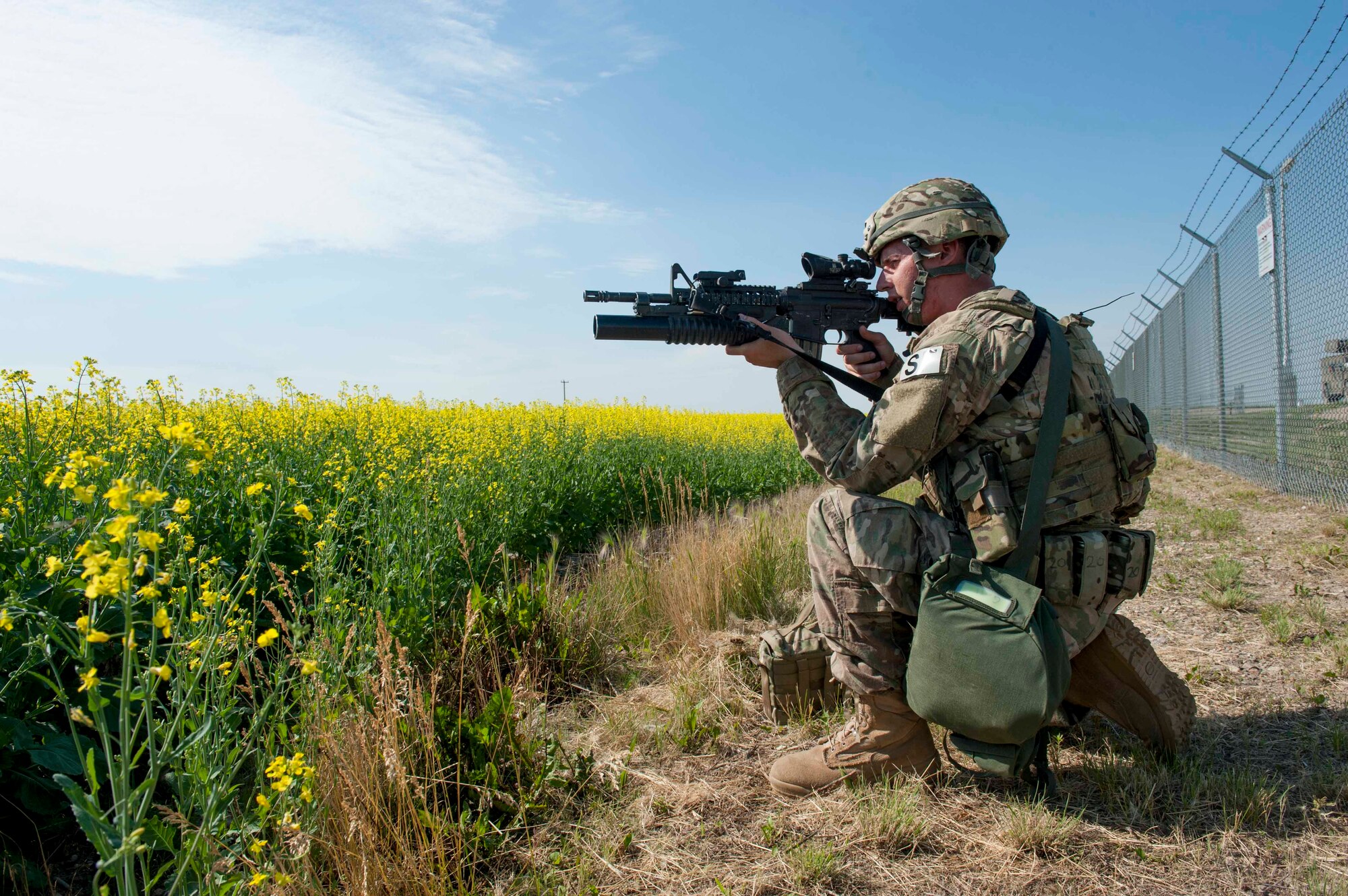A 91st Security Forces Group member guards the fence line of a launch facility during an exercise near Donnybrook, N.D., June 29, 2015. Airmen from 219th Security Forces Squadron and 791st Missile Security Forces Squadron worked together to pacify personnel dressed as simulated aggressors and recapture a launch facility. (U.S. Air Force photo/Airman 1st Class Sahara L. Fales)