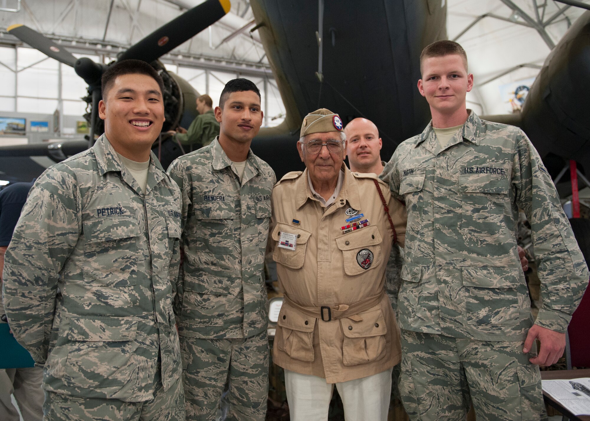Joe Morettini poses with Staff Sgt. Zachary Replogle, 373d Training Squadron military training leader, back, and C-5M Super Galaxy crew chief students July 9, 2015, at the Air Mobility Command Museum on Dover Air Force Base, Del. Several dozen people attended the Morettini visit. (U.S. Air Force photo/Airman 1st Class Zachary Cacicia)