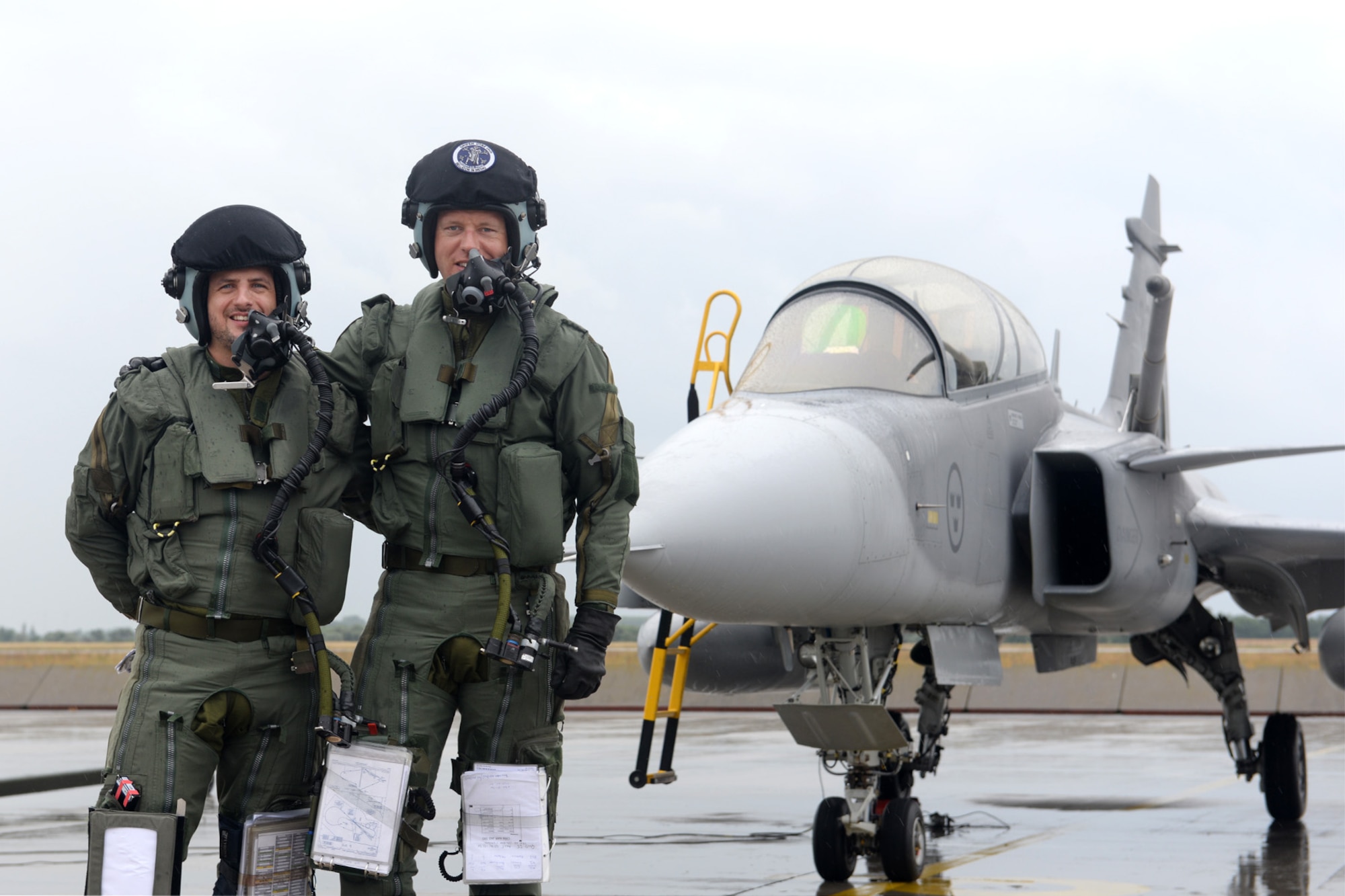 A Hungarian air force JAS-39 Gripen pilot, left, and Swedish air force Capt. Fredrik Borgsrtöm, Swedish AF Gripen Operational Testing and Evaluation instructor pilot, pose for a photo after completing the first air refueling training sortie in Hungarian history June 24, 2015, during air refueling familiarization training on Kecskemét air base, Hungary. Hungarian, U.S. and Swedish air force personnel met for a two-week familiarization period enabling the Hungarian JAS-39 Gripen pilots to successfully perform air refueling for the first time. (U.S. Air Force photo by Senior Airman Kate Thornton/Released)