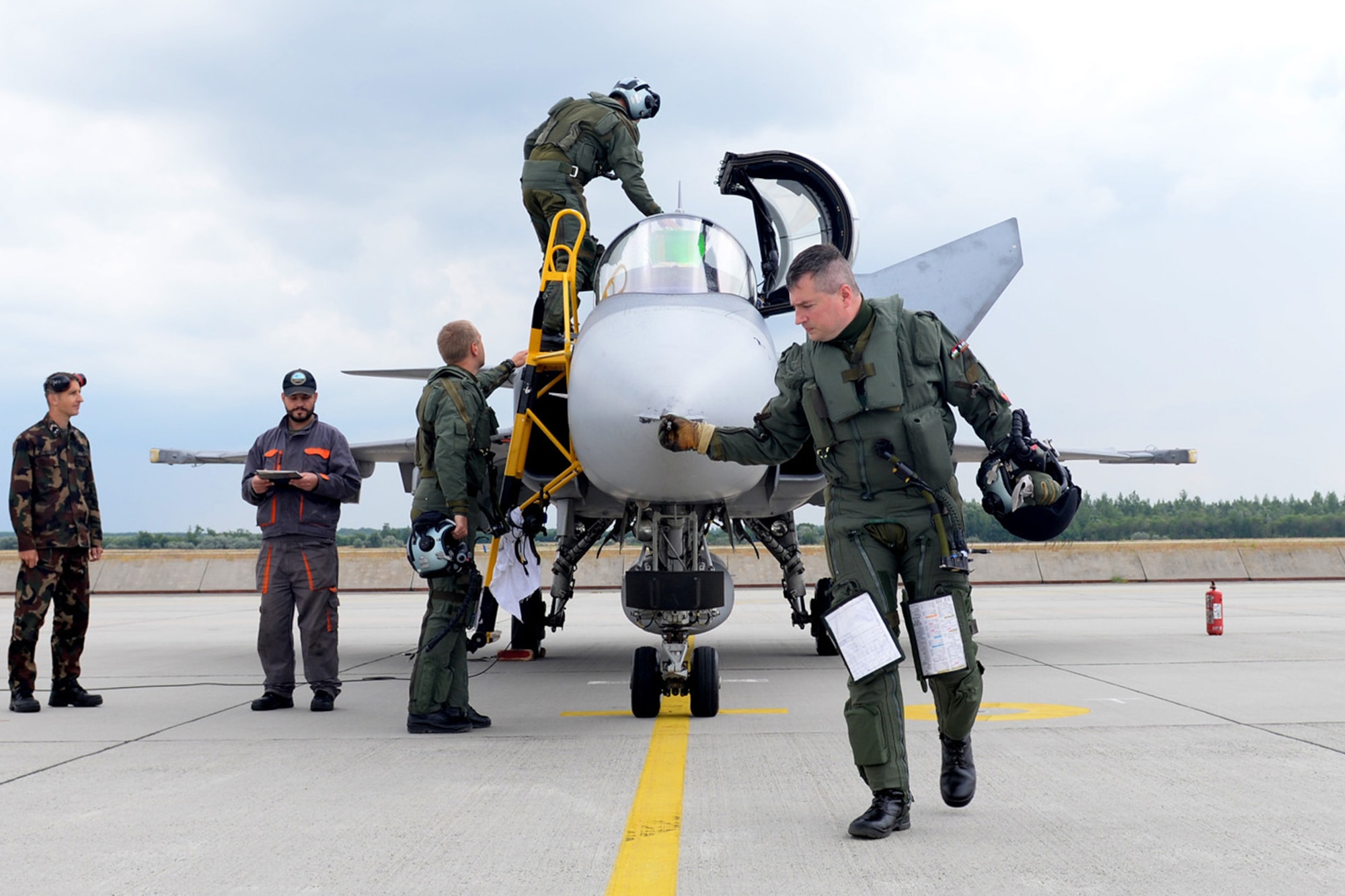 Hungarian and Swedish air force JAS-39 Gripen pilots perform a pre-flight inspection on their jet prior to take-off June 24, 2015, during air refueling familiarization training on Kecskemét air base, Hungary. Hungarian, U.S. and Swedish air force personnel met for a two-week familiarization period enabling the Hungarian JAS-39 Gripen pilots to successfully perform air refueling for the first time. (U.S. Air Force photo by Senior Airman Kate Thornton/Released)