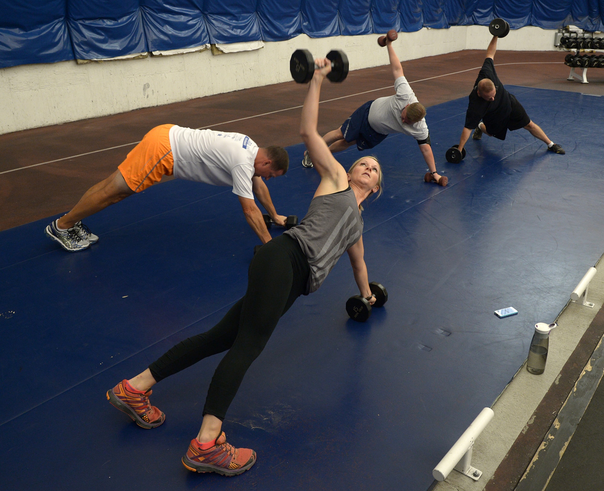 Tech. Sgt. Kristina Decot, noncommissioned officer in charge of Chapel Operations (far right), leads Hill Air Force Base Chaplains Maj. Scott Baker (center), Maj. Erik Harp and Capt. Jeremy Caskey (top) in a fitness routine June 30 to meet the physical pillar of Comprehensive Airman Fitness. CAF is a lifestyle and culture that focuses on mental and physical wellness, social activities, family, peer and mentor support and spiritual health. (Alex R. Lloyd/U.S. Air Force)