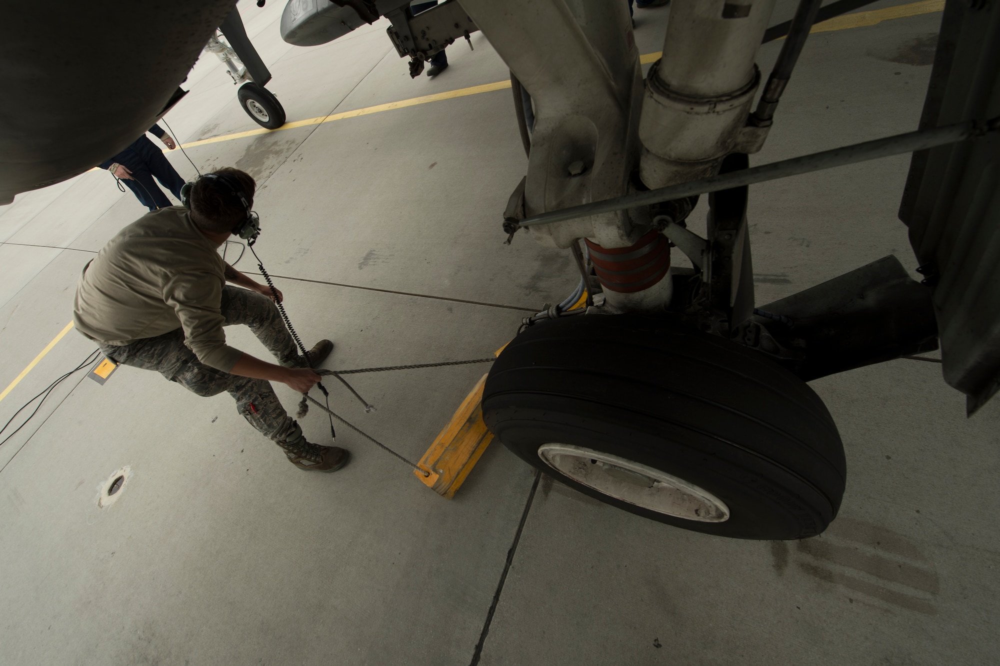 A U.S. Air Force maintenance Airman assigned to the 354th Expeditionary Fighter Squadron removes the chalks from an A-10 Thunderbolt II attack aircraft during a theater security package deployment to Lask Air Base, Poland, July 10, 2015. The U.S. is committed to acting collectively with its NATO Allies and the international community to address security challenges. (U.S. Air Force photo by Staff Sgt. Christopher Ruano/Released)