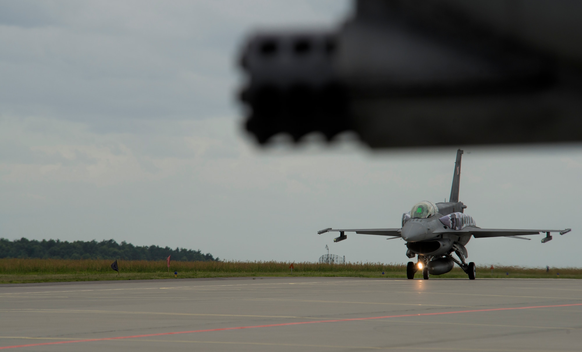 A Polish air force F-16 Fighting Falcon fighter aircraft pilot taxi's near an A-10 Thunderbolt II attack aircraft assigned to the 354th Expeditionary Fighter Squadron during a theater security package deployment to Lask Air Base, Poland, July 10, 2015. The 354th EFS aircraft have trained in more than five European countries during the TSP. (U.S. Air Force photo by Staff Sgt. Christopher Ruano/Released)