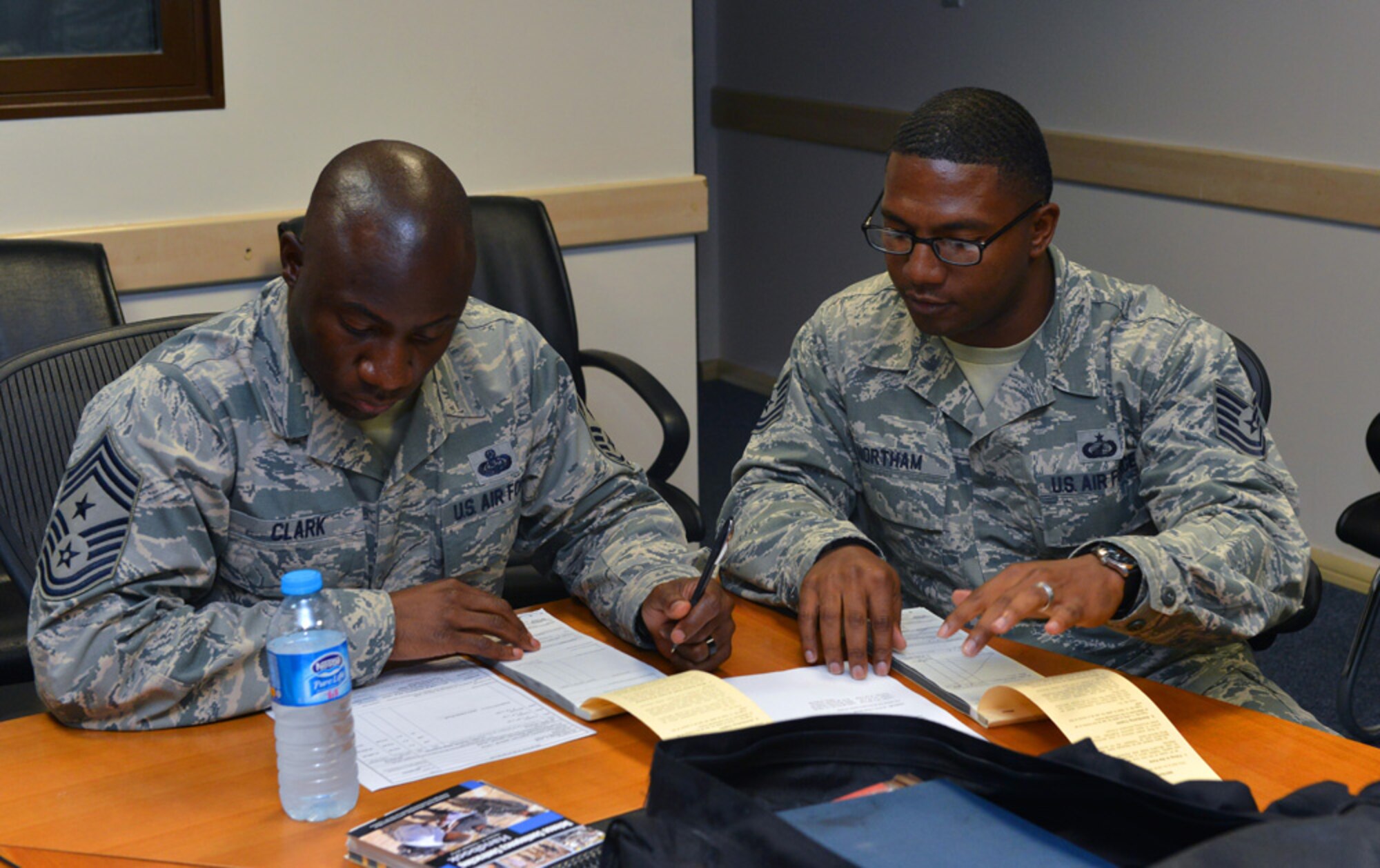 Tech. Sgt. Nicholas Northam, 39th Contracting Squadron contract officer, instructs Chief Master Sgt. Vegas Clark, 39th Air Base Wing command chief, on the proper way to fill out a contract form during a unit visit July 9, 2015, at Incirlik Air Base, Turkey. Clark met with Airmen of the 39th CONS as part of the commander’s Out Connecting with Airmen Program.  (U.S. Air Force photo by Senior Airman Michael Battles/Released)