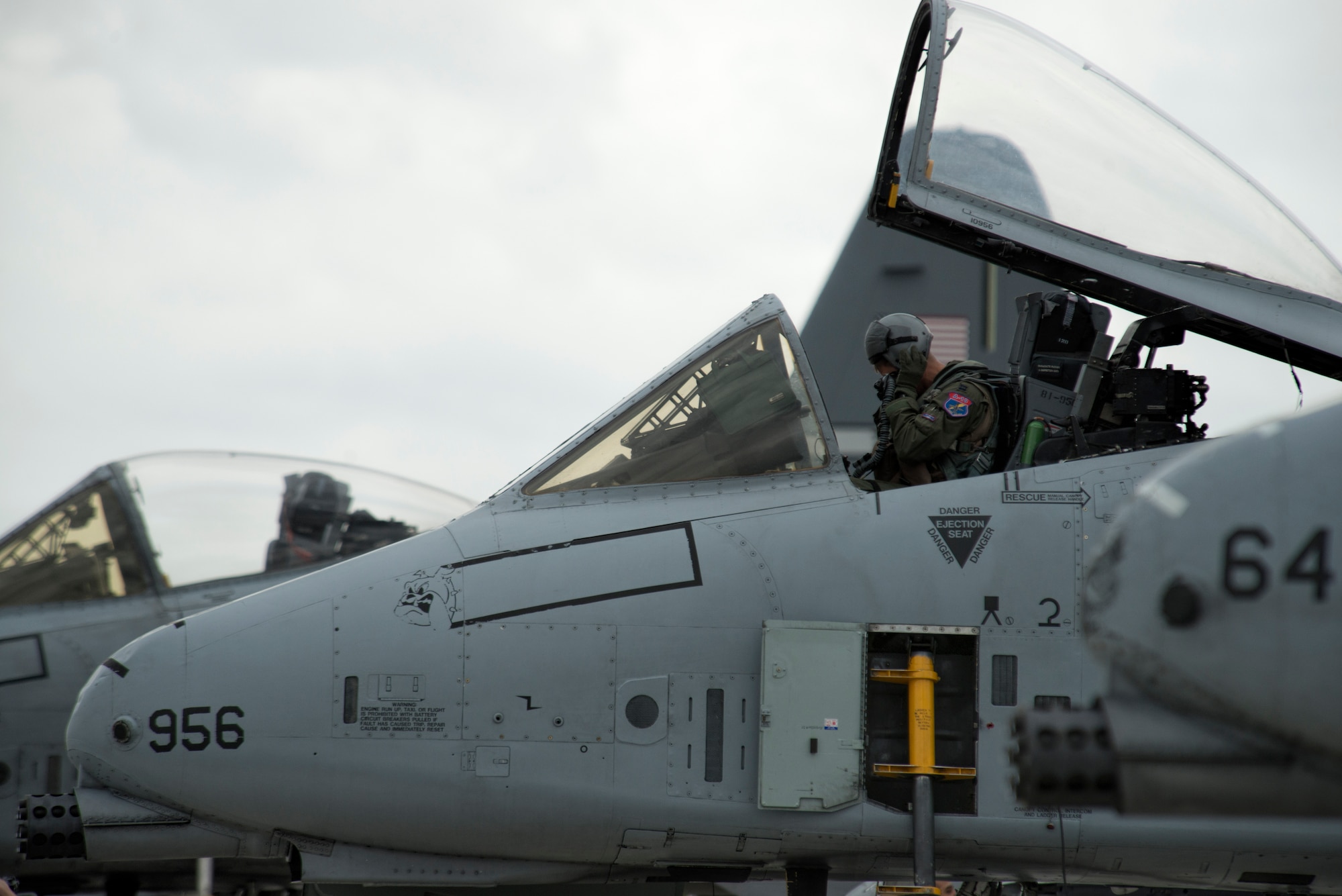 A U.S. Air Force A-10 Thunderbolt II attack aircraft pilot assigned to the 354th Expeditionary Fighter Squadron dons his helmet in preparation for flight during a theater security package deployment to Lask Air Base, Poland, July 10, 2015. The pilots will conduct training alongside NATO allies to strengthen interoperability and demonstrate U.S. commitment to the security and stability of Europe. (U.S. Air Force photo by Staff Sgt. Christopher Ruano/Released)
