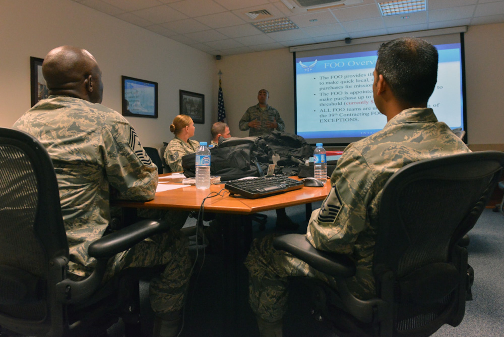 Staff Sgt. Pablo Velez, 39th Contracting Squadron contract officer, briefs Chief Master Sgt. Vegas Clark, 39th Air Base Wing command chief, during a unit visit July 9, 2015, at Incirlik Air Base, Turkey.  During his visit, Clark received several briefings on how to operate as a contracting officer during a contingency operation.  (U.S. Air Force photo by Senior Airman Michael Battles/Released)