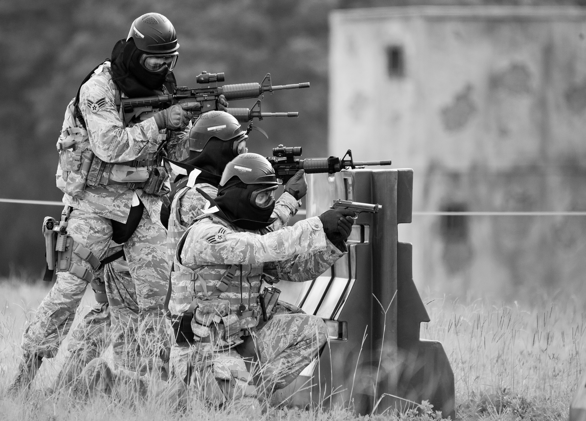 A team of 96th Security Forces Squadron Airmen prepare for a side-advancing movement during a shoot, move and communicate drill in June at Eglin Air Force Base, Fla.  The mandatory training requirement is in addition to annual weapons qualification training.  The exercise consists of Airmen firing simmunition ammo while advancing toward, away from and to the side of a target.  This is followed by a building sweep and clear drill.  The Defenders perform the highly kinetic training at Eglin’s Base Tango range.  The range was previously used for security forces pre-deployment training.  (U.S. Air Force photo/Samuel King Jr.)