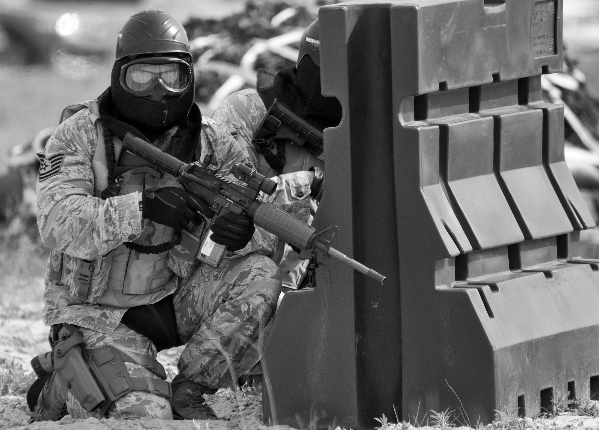 A 96th Security Forces Squadron Airman waits to advance during a shoot, move and communicate drill at Eglin Air Force Base, Fla.  The mandatory training requirement is in addition to annual weapons qualification training.  The exercise consists of Airmen firing simmunition ammo while advancing toward, away from and to the side of a target.  This is followed by a building sweep and clear drill.  The Defenders perform the highly kinetic training at Eglin’s Base Tango range.  The range was previously used for security forces pre-deployment training.  (U.S. Air Force photo/Samuel King Jr.)