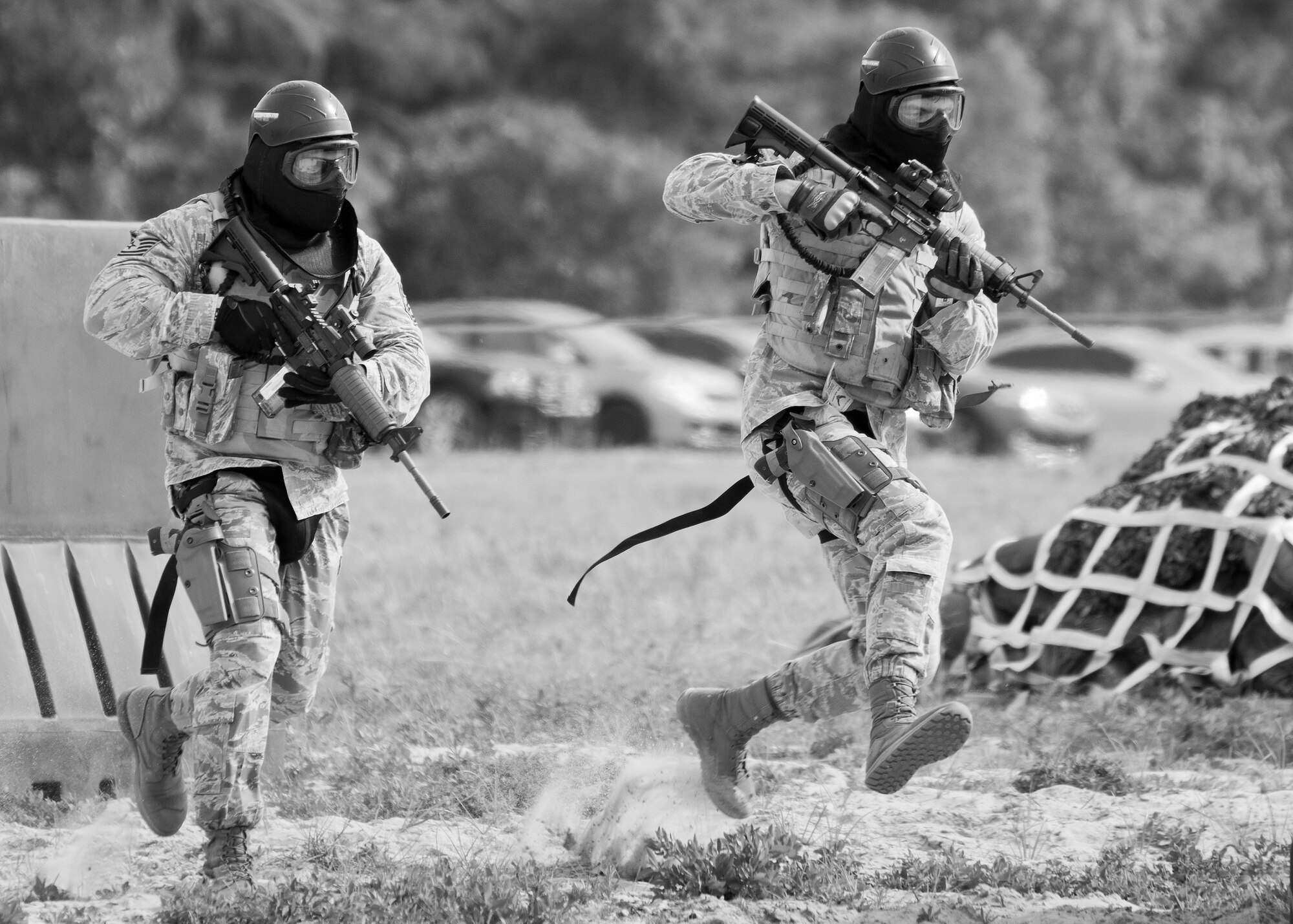 A 96th Security Forces Squadron Airman leads behind a barrier during a shoot, move and communicate drill at Eglin Air Force Base, Fla.  The mandatory training requirement is in addition to annual weapons qualification training.  The exercise consists of Airmen firing simmunition ammo while advancing toward, away from and to the side of a target.  This is followed by a building sweep and clear drill.  The Defenders perform the highly kinetic training at Eglin’s Base Tango range.  The range was previously used for security forces pre-deployment training.  (U.S. Air Force photo/Samuel King Jr.)