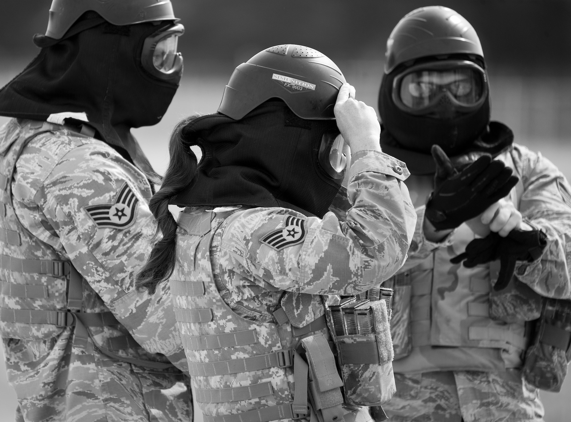 A 96th Security Forces Squadron Airman secures her helmet prior to a shoot, move and communicate drill at Eglin Air Force Base, Fla.  The mandatory training requirement is in addition to annual weapons qualification training.  The exercise consists of Airmen firing simmunition ammo while advancing toward, away from and to the side of a target.  This is followed by a building sweep and clear drill.  The Defenders perform the highly kinetic training at Eglin’s Base Tango range.  The range was previously used for security forces pre-deployment training.  (U.S. Air Force photo/Samuel King Jr.)