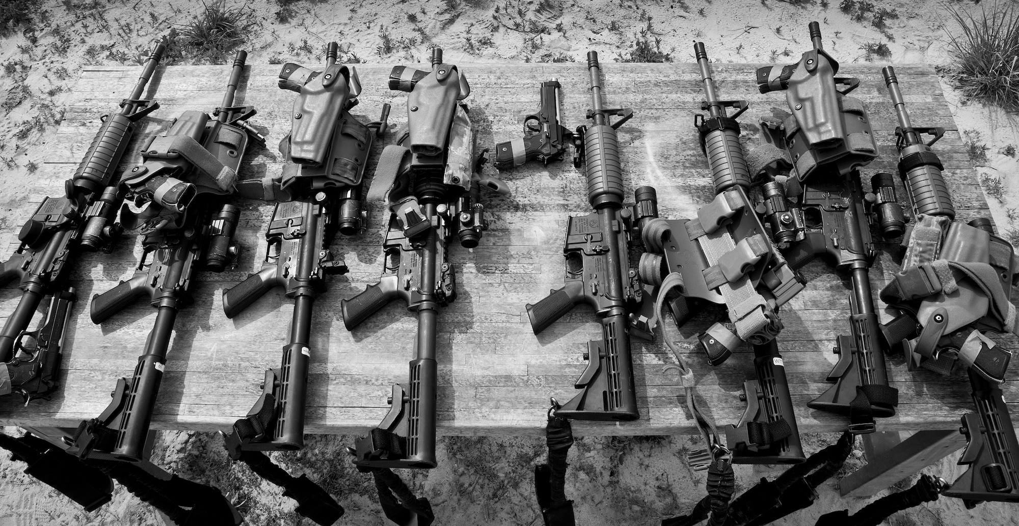 M-4 rifles and M-9 pistols sit ready for use by 96th Security Forces Squadron Airmen prior to a shoot, move and communicate drill at Eglin Air Force Base, Fla.  The mandatory training requirement is in addition to annual weapons qualification training.  The exercise consists of Airmen firing simmunition ammo while advancing toward, away from and to the side of a target.  This is followed by a building sweep and clear drill.  The Defenders perform the highly kinetic training at Eglin’s Base Tango range.  The range was previously used for security forces pre-deployment training.  (U.S. Air Force photo/Samuel King Jr.)