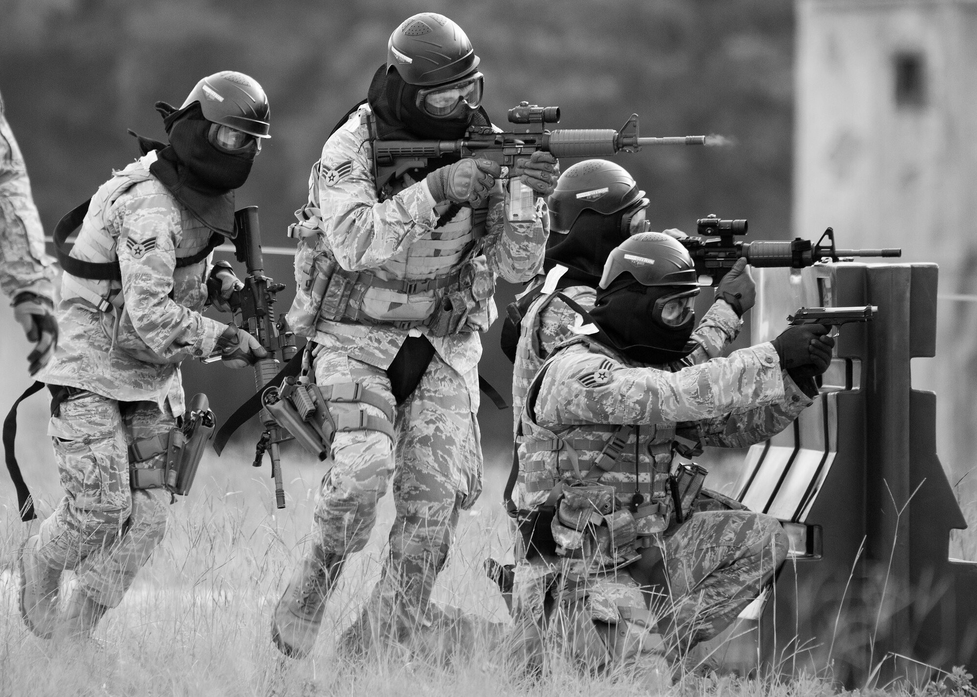 A team of 96th Security Forces Squadron Airmen perform a side-advancing movement during a shoot, move and communicate drill in June at Eglin Air Force Base, Fla.  The mandatory training requirement is in addition to annual weapons qualification training.  The exercise consists of Airmen firing simmunition ammo while advancing toward, away from and to the side of a target.  This is followed by a building sweep and clear drill.  The Defenders perform the highly kinetic training at Eglin’s Base Tango range.  The range was previously used for security forces pre-deployment training.  (U.S. Air Force photo/Samuel King Jr.)
