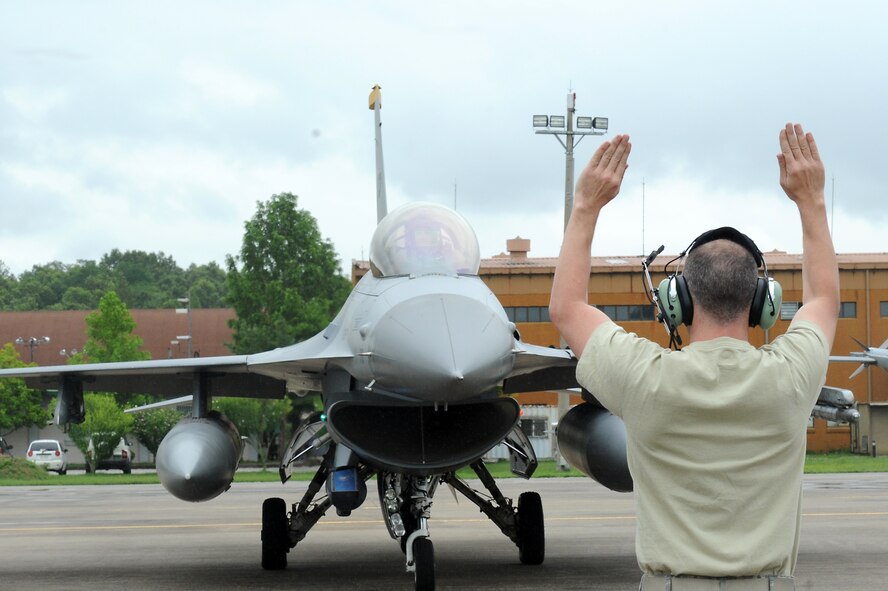 Staff Sgt. Kenneth Heber, 80th Aircraft Maintenance Unit crew chief, marshals in an F-16 Fighting Falcon during Buddy Wing 15-6 at Jungwon Air Base, Republic of Korea, July 8, 2015. Buddy Wing is part of a combined fighter exchange program designed to improve interoperability between U.S. Air Force and ROKAF fighter squadrons and are conducted multiple times throughout the year in order to promote cultural awareness and sharpen combined combat capabilities. (U.S. Air Force photo by Senior Airman Divine Cox/Released)