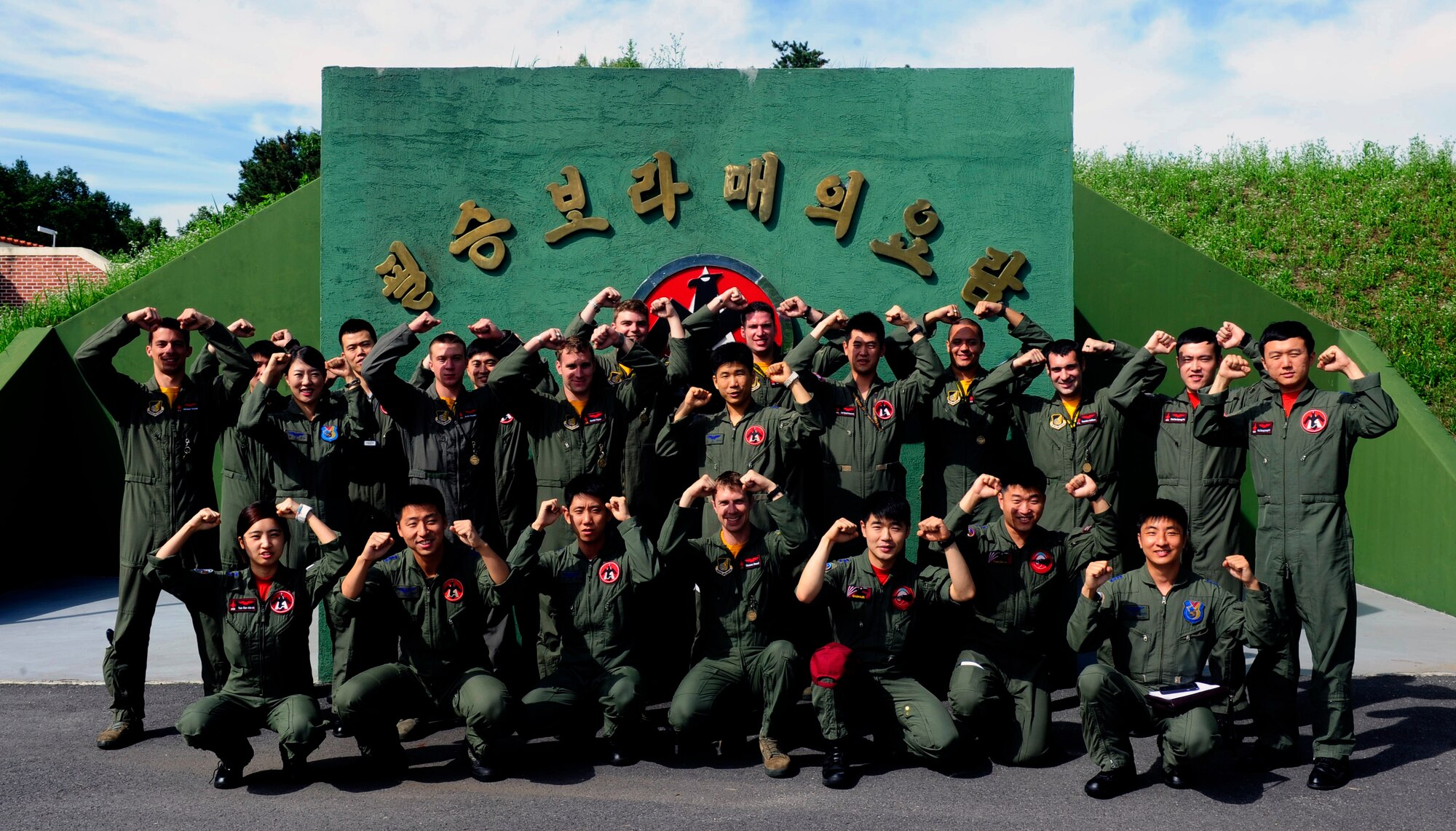 Republic of Korea Air Force KF-16 Fighting Falcon pilots from the 19th Fighter Wing and F-16 pilots from the 80th Fighter Squadron, Kunsan Air Base, Republic of Korea, render a “crush ‘em” gesture at Jungwon Air Base, ROK, during Buddy Wing 15-6, July 8, 2015. In an effort to enhance U.S. and ROKAF air combat capability, Buddy Wing exercises are conducted multiple times throughout the year on the peninsula to sharpen interoperability between the allied forces so that if need be, they are always ready to fight as a combined force. (U.S. Air Force photo by Staff Sgt. Nick Wilson/Released) 