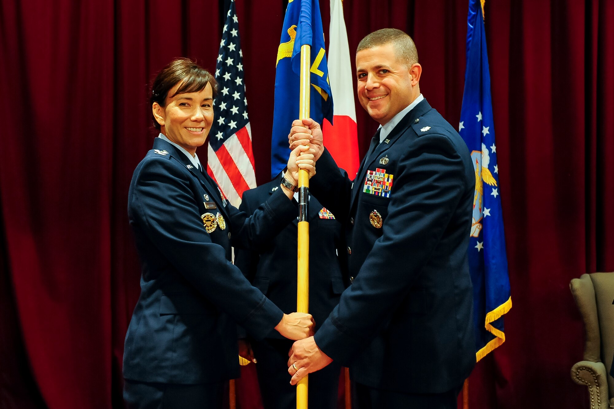 U.S. Air Force Col. Debra A. Lovette, 18th Mission Support Group commander, passes the 18th Logistics Readiness Squadron guidon to Lt. Col. Patrick Launey, newly appointed commander of the 18th LRS, during a change of command ceremony on Kadena Air Base, Japan, July 13, 2015. Launey is now responsible for leading the largest LRS in the Air Force, composed of 761 military and civilian personnel across four flights. (U.S. Air Force photo by Airman 1st Class John Linzmeier)