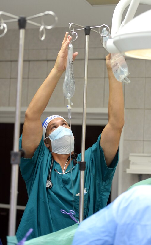 U.S. Air Force Maj. Frederick Grois replaces the intravenous fluid bags for a patient undergoing gallbladder surgery in the operating room at the Doctor Salvador Paredes Hospital in Trujillo, Honduras, July 2, 2015. Grois is an anesthesiologist assigned to the 779th Medical Operations Squadron.