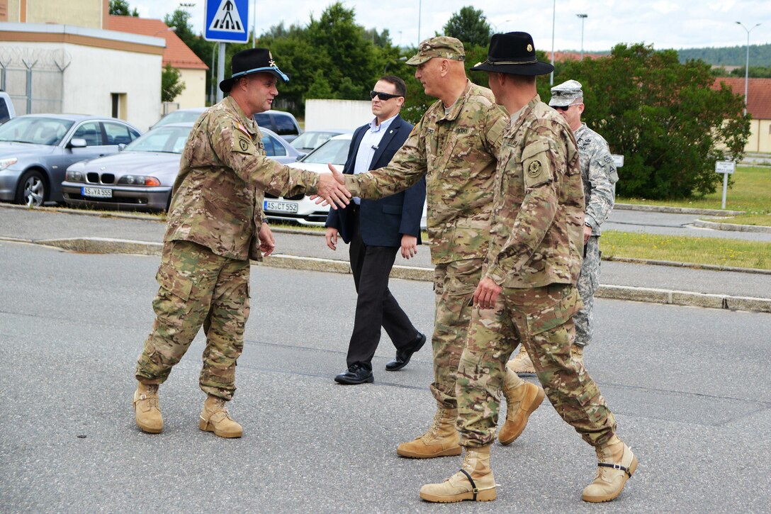 U.S. Army Sgt. Maj. Shane E. Pospisil, left, shakes hands with U.S. Army Chief of Staff Gen. Ray Odierno, center, as U.S. Army Col. John V. Meyer, right, looks on during his visit to Rose Barracks in Vilseck, Germany, July 9, 2015. Meyer is the commander of the 2nd Cavalry Regiment, and Pospisil is the unit's senior enlised advisor. 