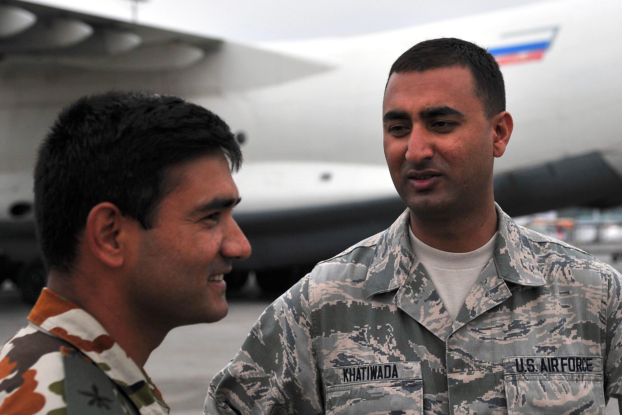 U.S. Air Force Senior Airman Manoj Khatiwada (right), 21st Medical Operations Squadron aerospace medical technician, talks with a Nepalese Army soldier, Tribhuvan International Airport in Kathmandu, Nepal, May 7, 2015. Manoj joined a team from the 36th Contingency Response Group to assist U.S. Air Force, U.S. Department of State and U.S. Agency for International Development operations by assisting with communicating with the Nepalese Army as they process relief supplies following a magnitude 7.8 earthquake that struck the region April 25, 2015. (U.S. Air Force photo by Maj. Ashley Conner/Released)