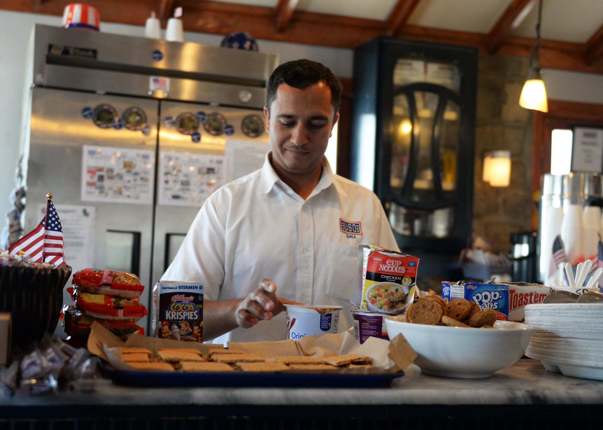 Sarhad Aziz, United Service Organization duty manager, places snacks out for visitors July 14, 2015, at the Pat Tillman Memorial Center, Bagram Airfield, Afghanistan. The Bagram USO is a facility for military members to go and relax in a comfortable environment as well as make free phone calls to loved ones.(U.S. Air Force photo by Senior Airman Cierra Presentado/Released)
