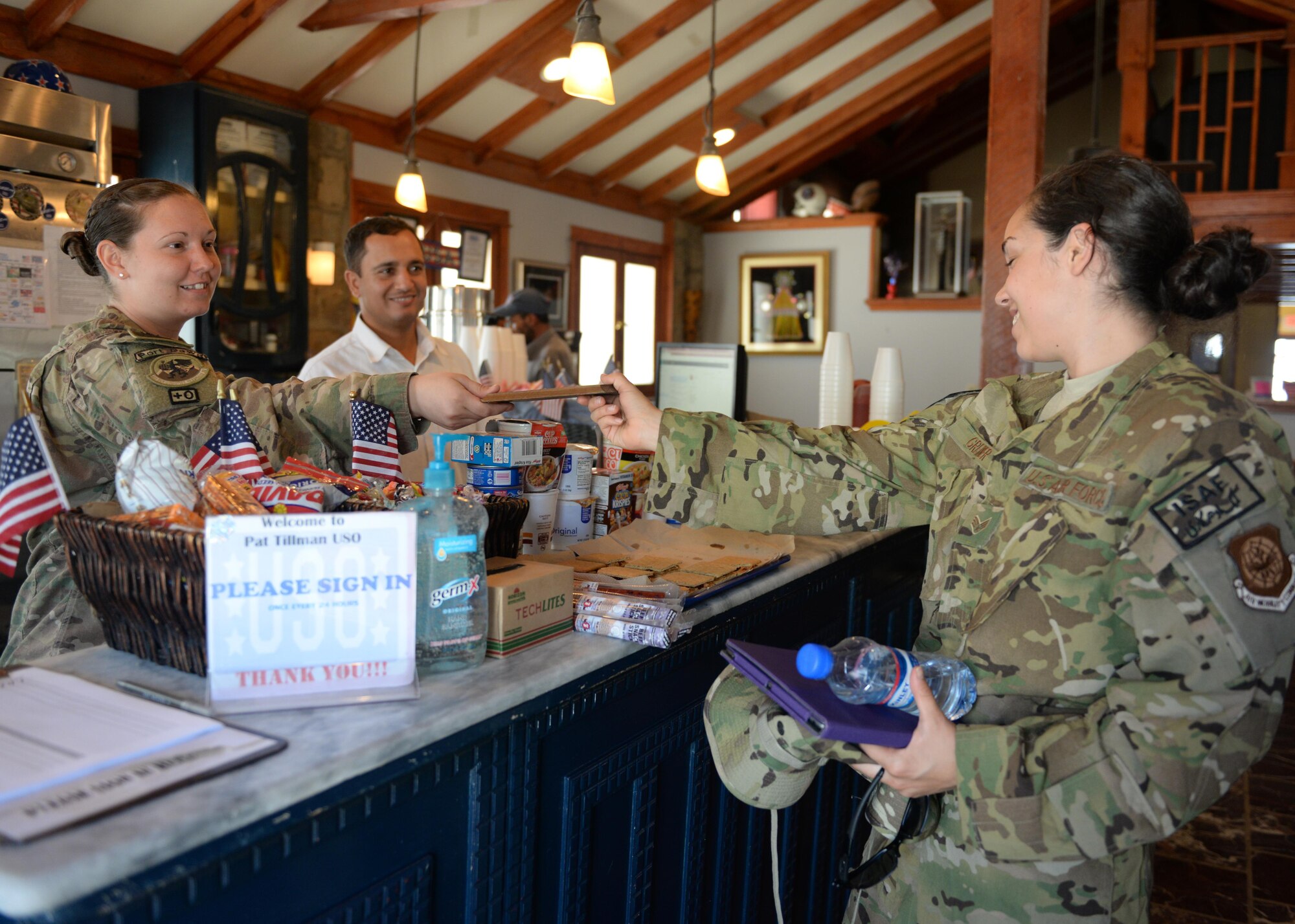 U.S. Senior Airman Jessica Greiner, assigned to the 774th Expeditionary Airlift Squadron loadmaster C-130J Super Hercules loadmaster, deployed from the 61st Airlift Squadron, Little Rock Air Force Base, Ark., accepts a calling card from USO staff members July 14, 2015, at Bagram Airfield, Afghanistan.  The Bagram USO is a facility for military members to go and relax in a comfortable environment as well as make free phone calls to loved ones.(U.S. Air Force photo by Senior Airman Cierra Presentado/Released)