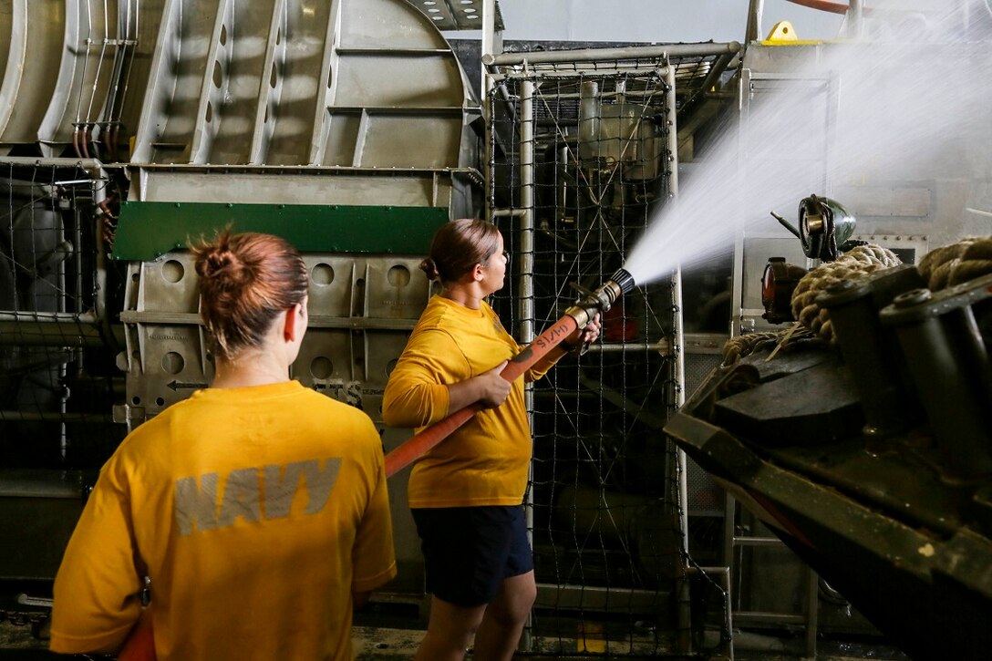 GULF OF OMAN  (July 12, 2015)  U.S. Navy Petty Officer 3rd Class Felicia Polk, right, washes down a landing craft, air cushion aboard the amphibious transport dock ship USS Anchorage (LPD 23).  Polk is a hull technician with Assault Craft Unit 5. Anchorage is part of the Essex Amphibious Ready Group and with the embarked 15th Marine Expeditionary Unit, is deployed in support of maritime security operations and theater security cooperation efforts in the U.S. 5th Fleet area of operations. (U.S. Marine Corps photo by Sgt. Jamean Berry/Released)