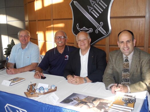 Chief Master Sgt. Matt Proietti, right, with (right to left) Col. (retired) Joe Panza and Richard and Cory Etchberger, at the release of At All Costs, Proietti's new book on the life and death of Chief Master Sgt. Richard L. Etchberger, a Vietnam War Medal of Honor recipient. 