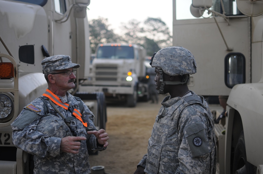 (Left) Staff Sgt. Dean Long and Pfc. Harvey Rohando, motor transport operators with the 630th Transportation Company, discus convoy safety standards prior to the departure of their petroleum supply convoy during a Quartermaster Liquid Logistics Exercise (QLLEX) at Fort Bragg, N.C., June. 12, 2015 QLLEX is an annual logistical movement event that will transport necessary petroleum and purified water throughout the U.S. (Sgt. Christopher Bigelow / Released)