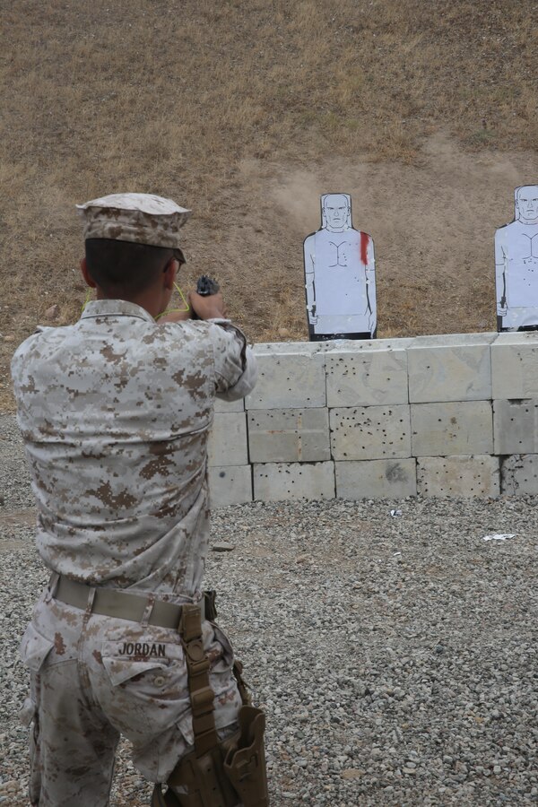 Lance Cpl. Travis Jordan, a combat photographer with Headquarters and Headquarters Squadron and an Orlando, Florida, native, shoots the M9 pistol during security augment force (SAF) training aboard Marine Corps Air Station Miramar, California, July 1. Service members also trained with the M1014 shotgun. (Official U.S. Marine Corps photo by Lance Cpl. Kimberlyn Adams/Released)