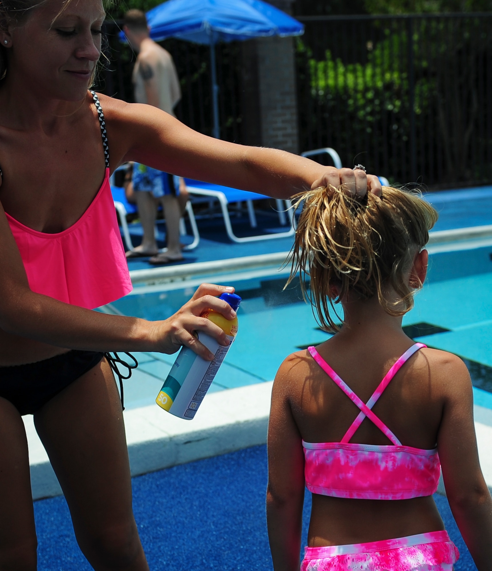 Sunscreen is sprayed on before swimming at the Hurlburt Aquatic Center on Hurlburt Field, Fla., July 12, 2015. The Hurlburt Aquatic Center extended open swim hours to include Sundays from 1-5 p.m. (U.S. Air Force photo by/Senior Airman Meagan Schutter)